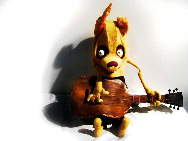 stuffed creature holding a guitar