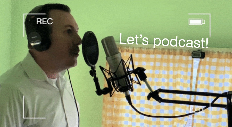 Bill Selak selfie talking into a large diaphragm microphone in a light green podcast studio